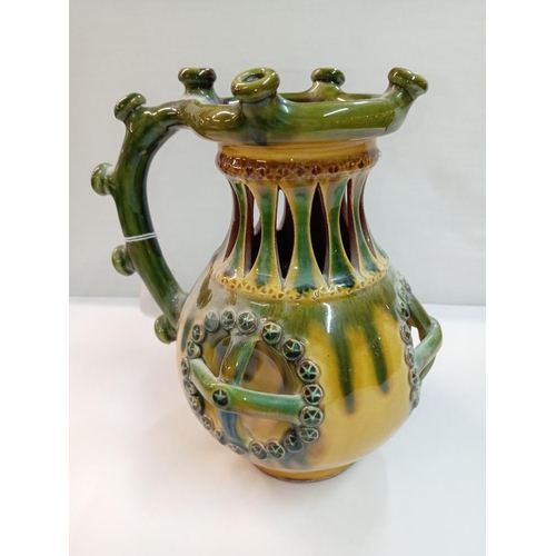 1261 - A signed slip glaze puzzle jug. Height 22cm