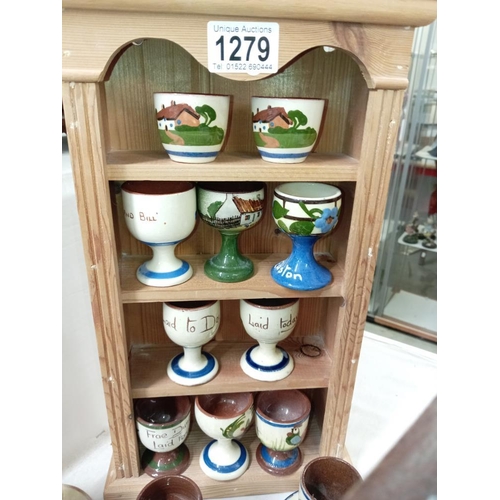 1279 - 17 egg cups on pine display stand