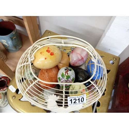 1210 - A good selection of eggs in wire basket including polished stone cloisonne & wood