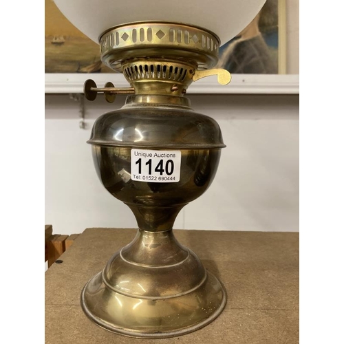 1140 - A brass oil lamp with frosted shade