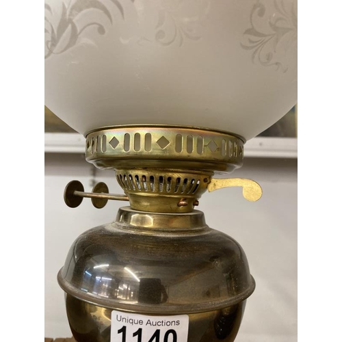 1140 - A brass oil lamp with frosted shade