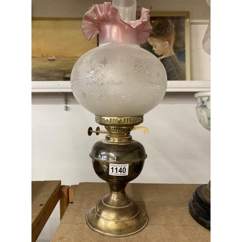 1140 - A brass oil lamp with frosted shade