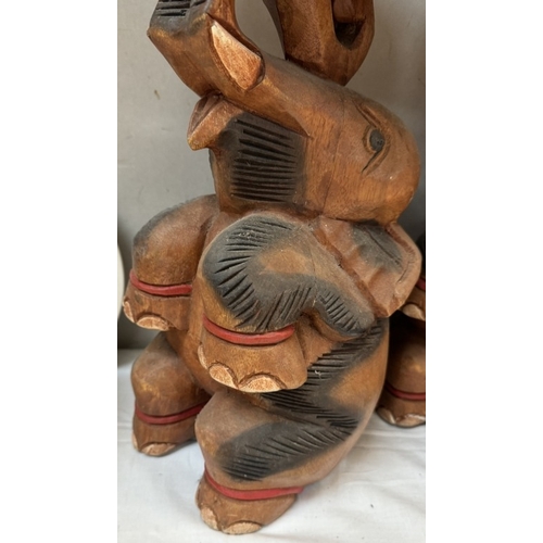 451 - A pair of solid teak sitting elephant plant stands. Height 41cm