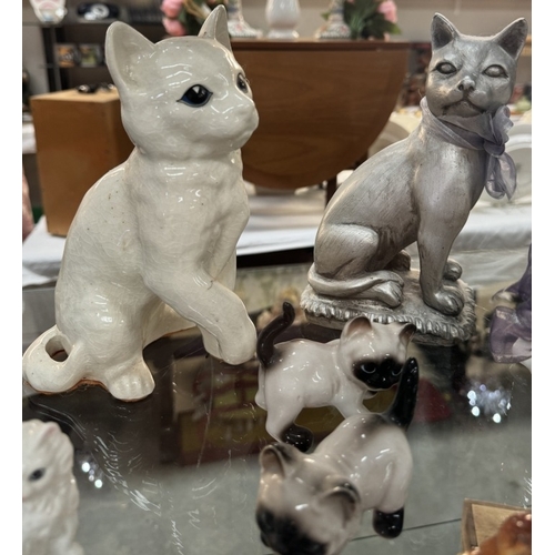 674 - A large lot of pottery cat figures