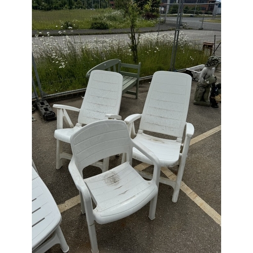 577 - A sun lounger, 4 recliner chairs & 2 solid armchairs. All in white plastic.