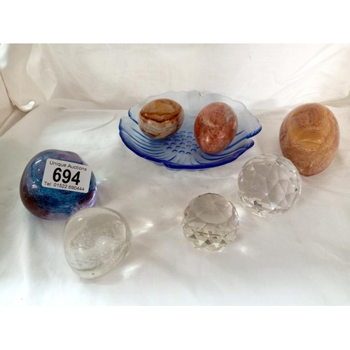 694 - A quantity of paperweights 'Egg' stones, A daisy blue glass dish etc