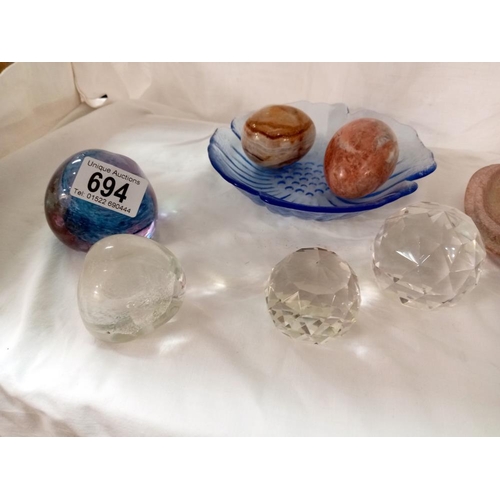 694 - A quantity of paperweights 'Egg' stones, A daisy blue glass dish etc