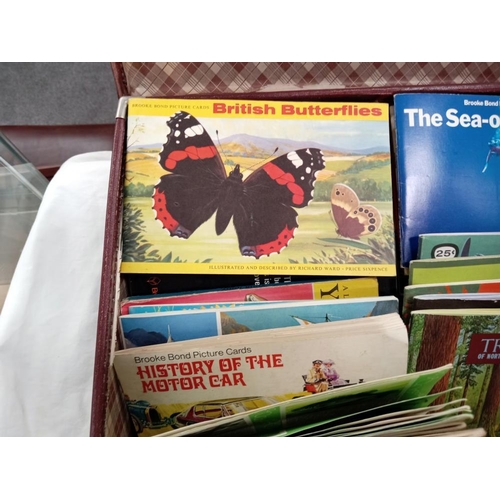 709 - A vintage suitcase of Brooke Bond tea cards & books