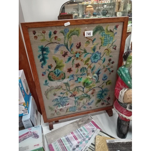 746 - A vintage oak framed fire screen with wool work tapestry centre