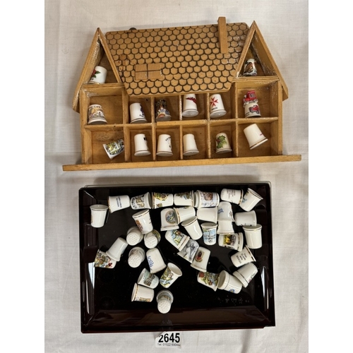 2645 - A quantity of porcelain thimbles & a small display shelf