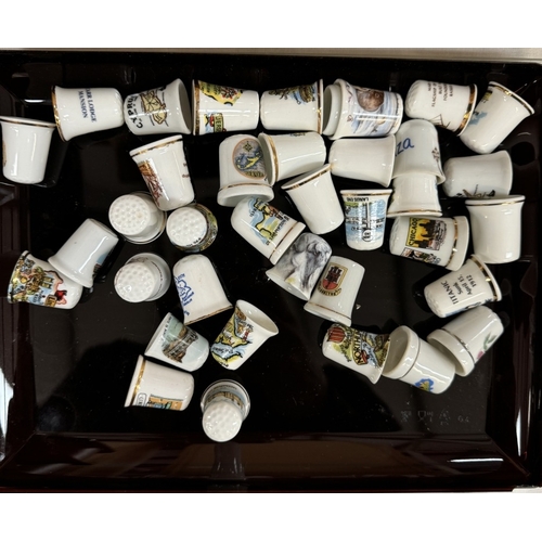 2645 - A quantity of porcelain thimbles & a small display shelf