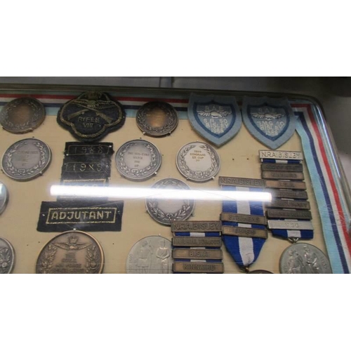 1134 - A cased collection of Royal Air Force Small Arms association medals and badges.