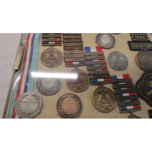 1134 - A cased collection of Royal Air Force Small Arms association medals and badges.