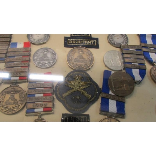 1134 - A cased collection of Royal Air Force Small Arms association medals and badges.