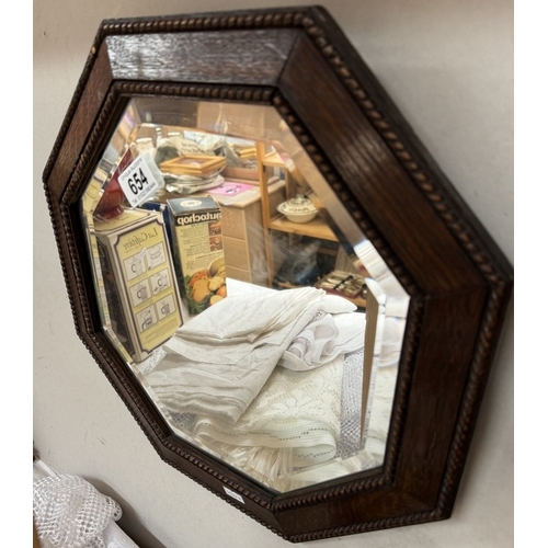 654 - A 1930's oak framed octagonal bevel edge mirror