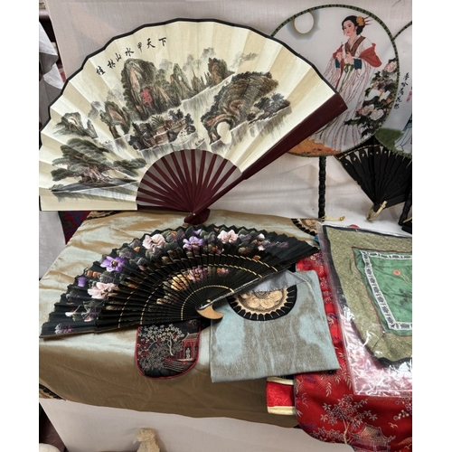 867 - A quantity of Oriental fans & silks etc.