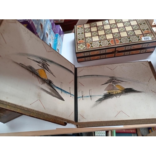 891 - An oriental lacquered postcard album with hand painted fabric covered pages