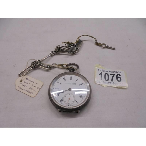 1076 - A Kendall & Dent silver pocket watch on a white metal Albert.