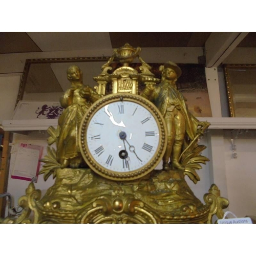 1096 - A gilded mantel clock surmounted two figures.