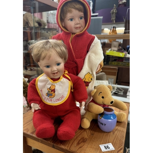 86 - 2 Porcelain dolls with Winnie The Pooh. (One in bathrobe)