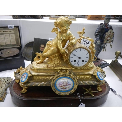 1814 - A French gilded mantel clock surmounted cherub figure and with Sevres porcelain panels, COLLECT ONLY... 