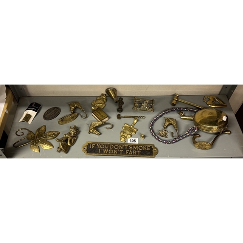 605 - A shelf of brass including door knockers, signs etc