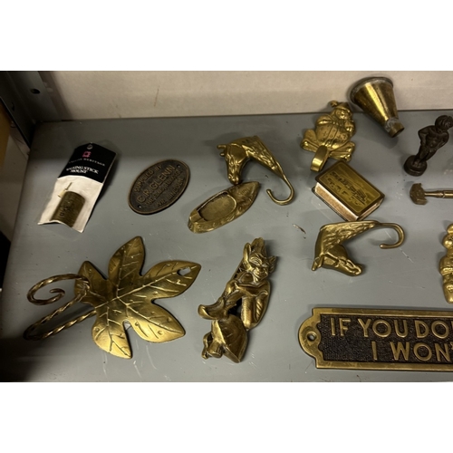 605 - A shelf of brass including door knockers, signs etc