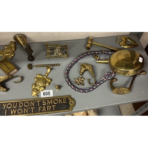 605 - A shelf of brass including door knockers, signs etc