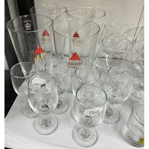 665 - A quantity of drinking glasses, including Bass advertising glasses and other glass items etc