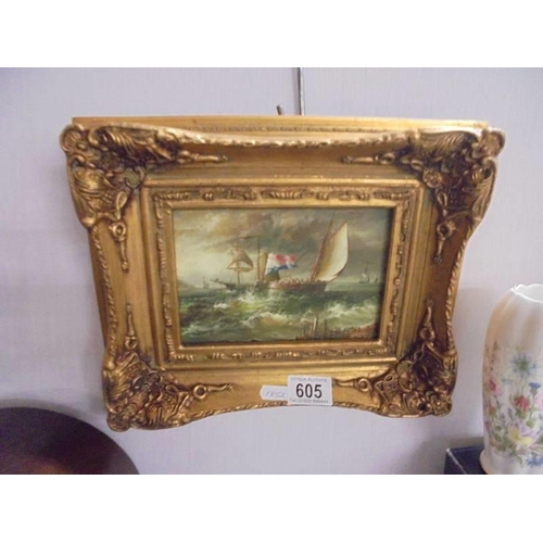 605 - A gilt framed overpainted print of a seascape.