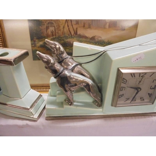 608 - An art deco three piece clock set featuring a lady in silver coloured dress and cap with two dogs.  ... 