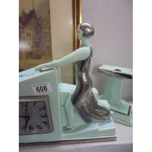 608 - An art deco three piece clock set featuring a lady in silver coloured dress and cap with two dogs.  ... 