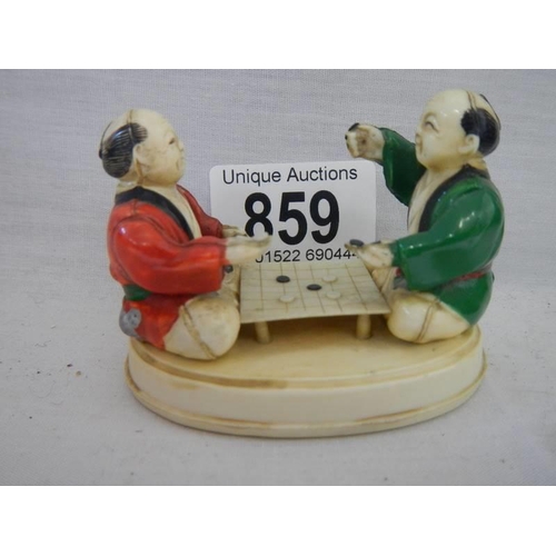 859 - An ivorex figure group of two Chinese men playing a board game.