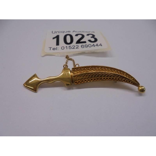 1023 - A gold dagger in sheath brooch with safety chain, (tests as 18ct), 7.12 grams.