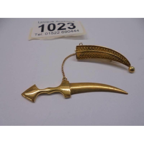 1023 - A gold dagger in sheath brooch with safety chain, (tests as 18ct), 7.12 grams.