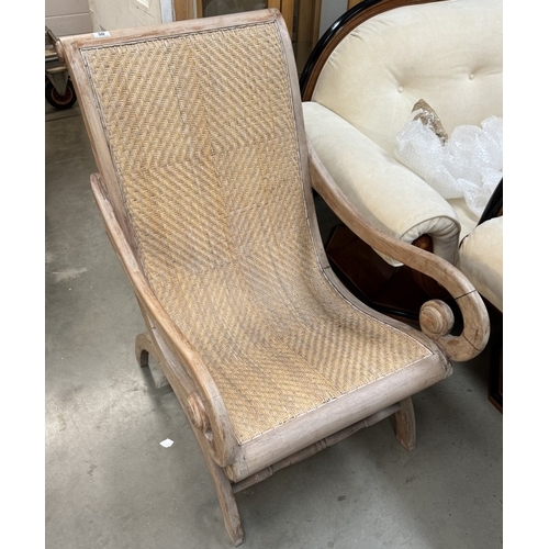 50 - A 1930’s plantation armchair with scroll arms and rattan seat and back.