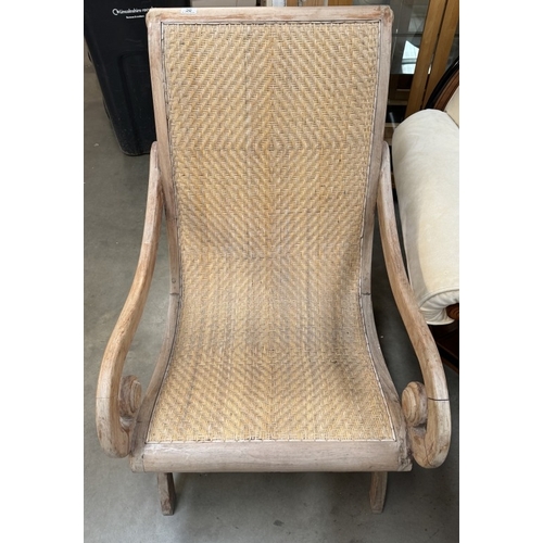 50 - A 1930’s plantation armchair with scroll arms and rattan seat and back.