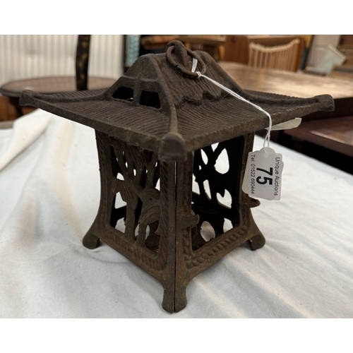 75 - A cast iron Japanese tea light holder in the shape of a pagoda with foliage design to the panels. To... 