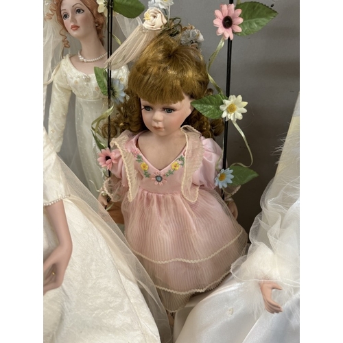 76 - 4 porcelain dolls, including 1 on a swing