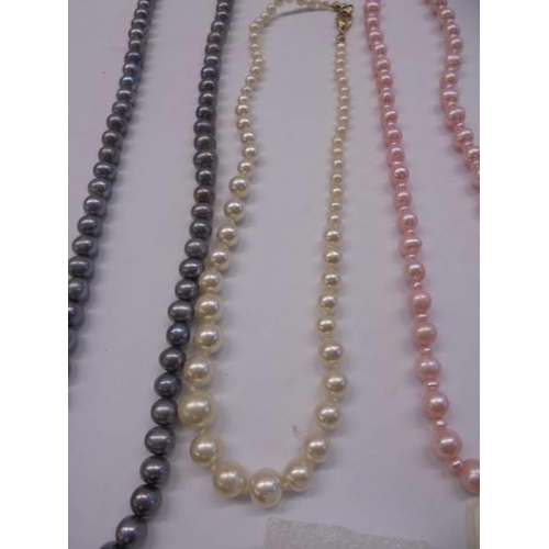 1048 - Three coloured pearl necklaces and a pair of pearl earrings.