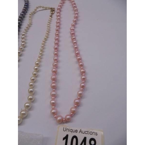 1048 - Three coloured pearl necklaces and a pair of pearl earrings.