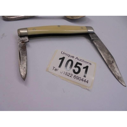 1051 - Two silver teaspoons and a double bladed penknife.