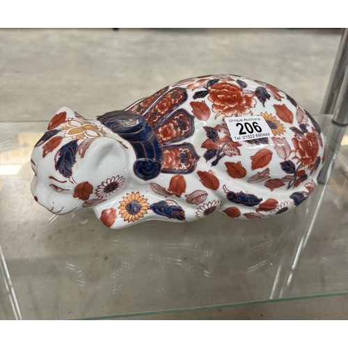 206 - A ceramic reclining cat.