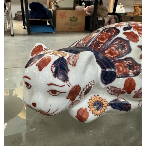 206 - A ceramic reclining cat.