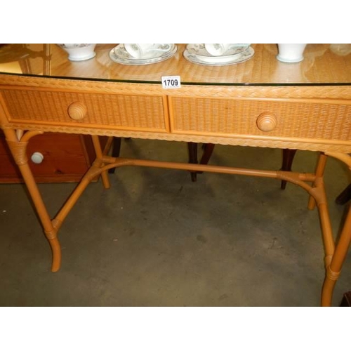 1709 - A good quality wicker side table with glass top and two drawers. COLLECT ONLY.