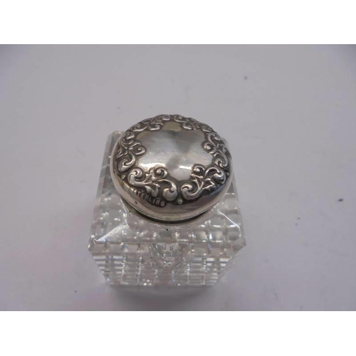 1063 - A glass inkwell with silver top.