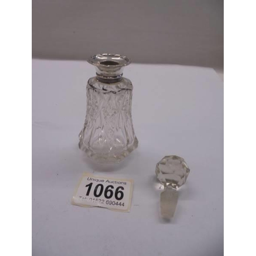 1066 - A cut glass scent bottle with silver top.