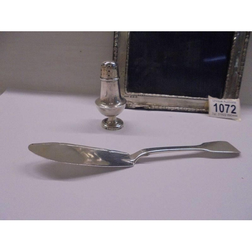 1072 - A silver photo frame, silver pepper pot and silver butter knife.