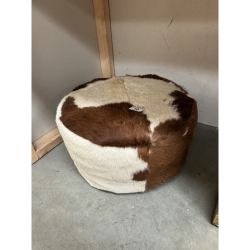 10 - A cowhide covered footstool pouffe