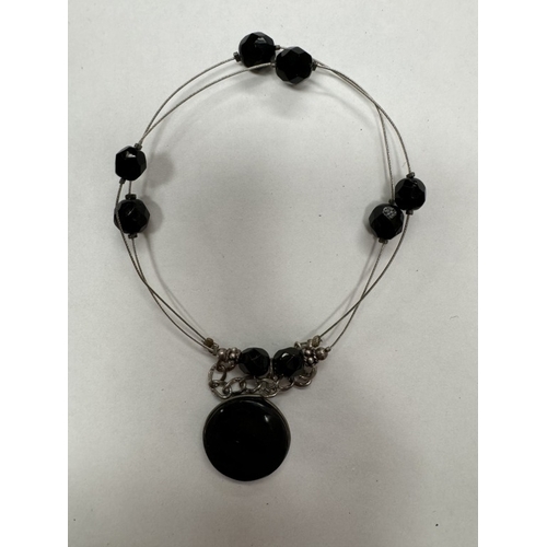 119 - An agate pendant on silver wire and a black haematite wood necklace with silver clasp